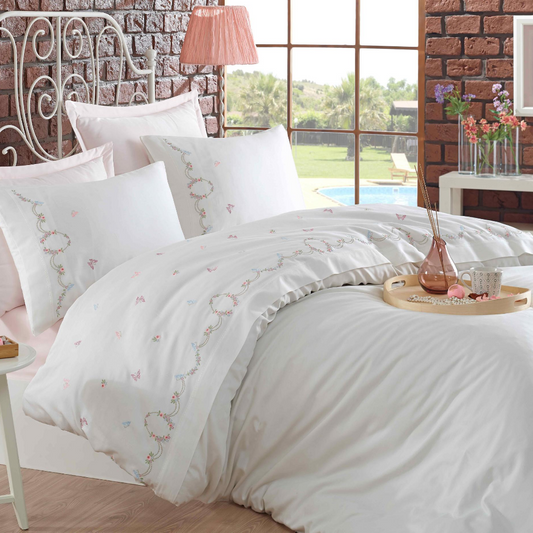 Feminine bedroom with white duvet cover that has pink, green, blue small floral embroideries on it