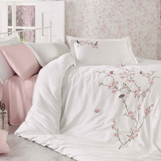 Fresh bedroom designed with white duvet cover, fully decorated with pink flowers and butterfly embroideries