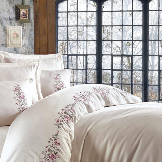Modern interior designed with creme quilt cover and pillows, decorated with floral ornaments.