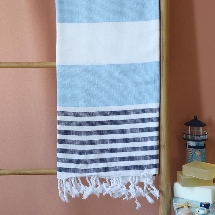 Absorbant, cotton beach towel has blue and navy stripes